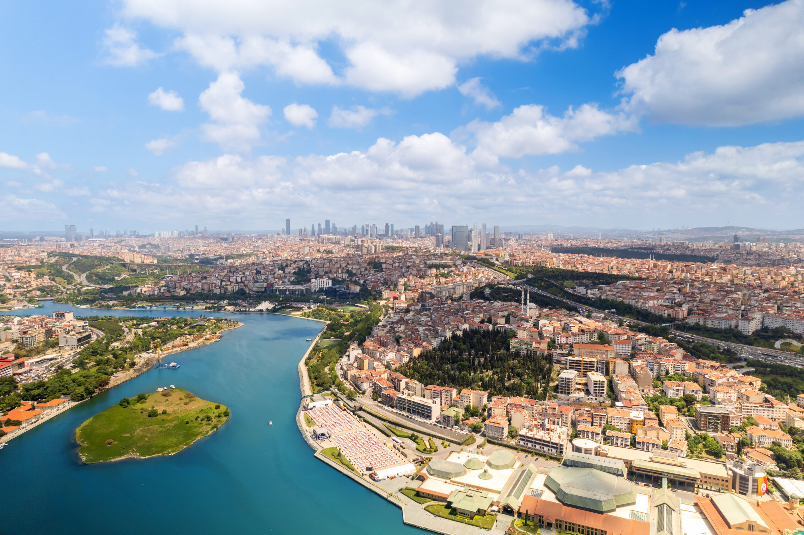 Aerial drone panoramic view of Istanbul, Turkey. Balat district with multiple residential buildings and greenery, Golden Horn waterway, downtown on the background