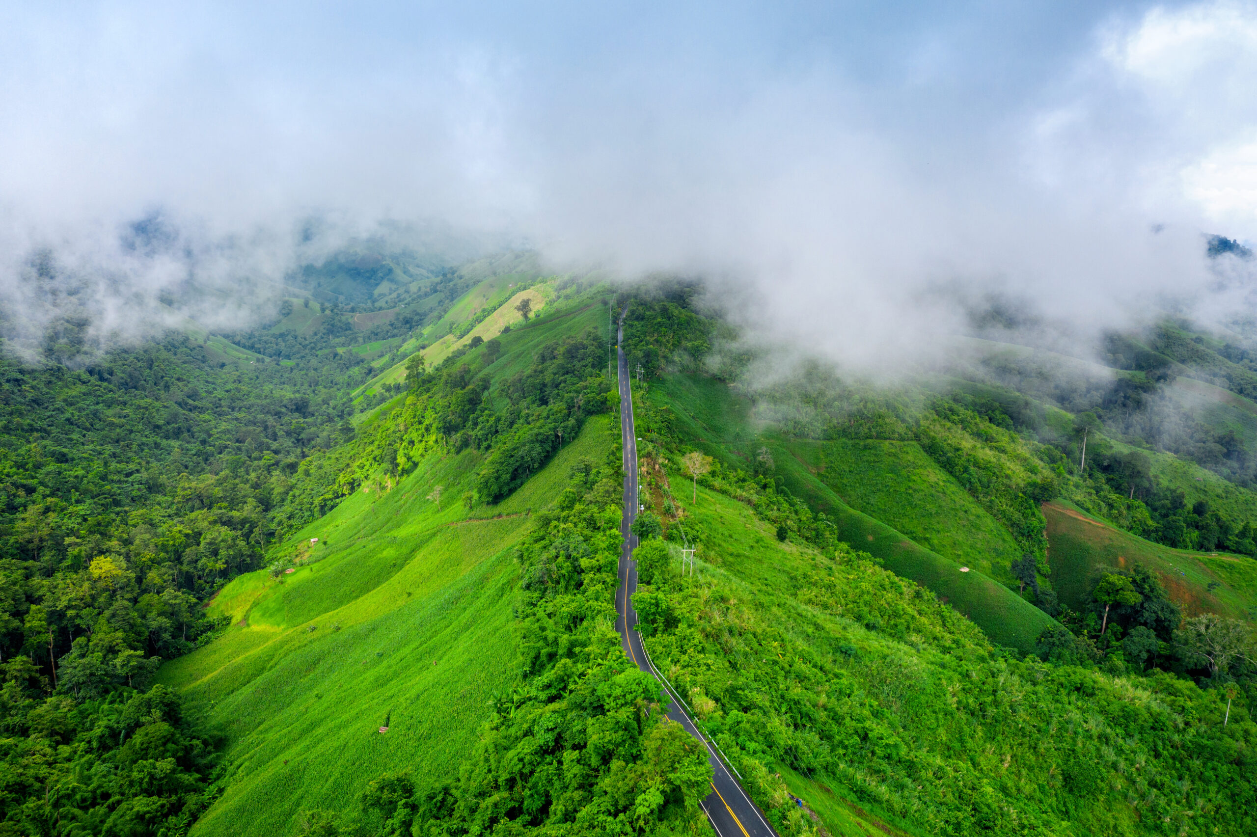 Aerial view of Beautiful sky road over top of mountains with green jungle in Nan province, Thailand.