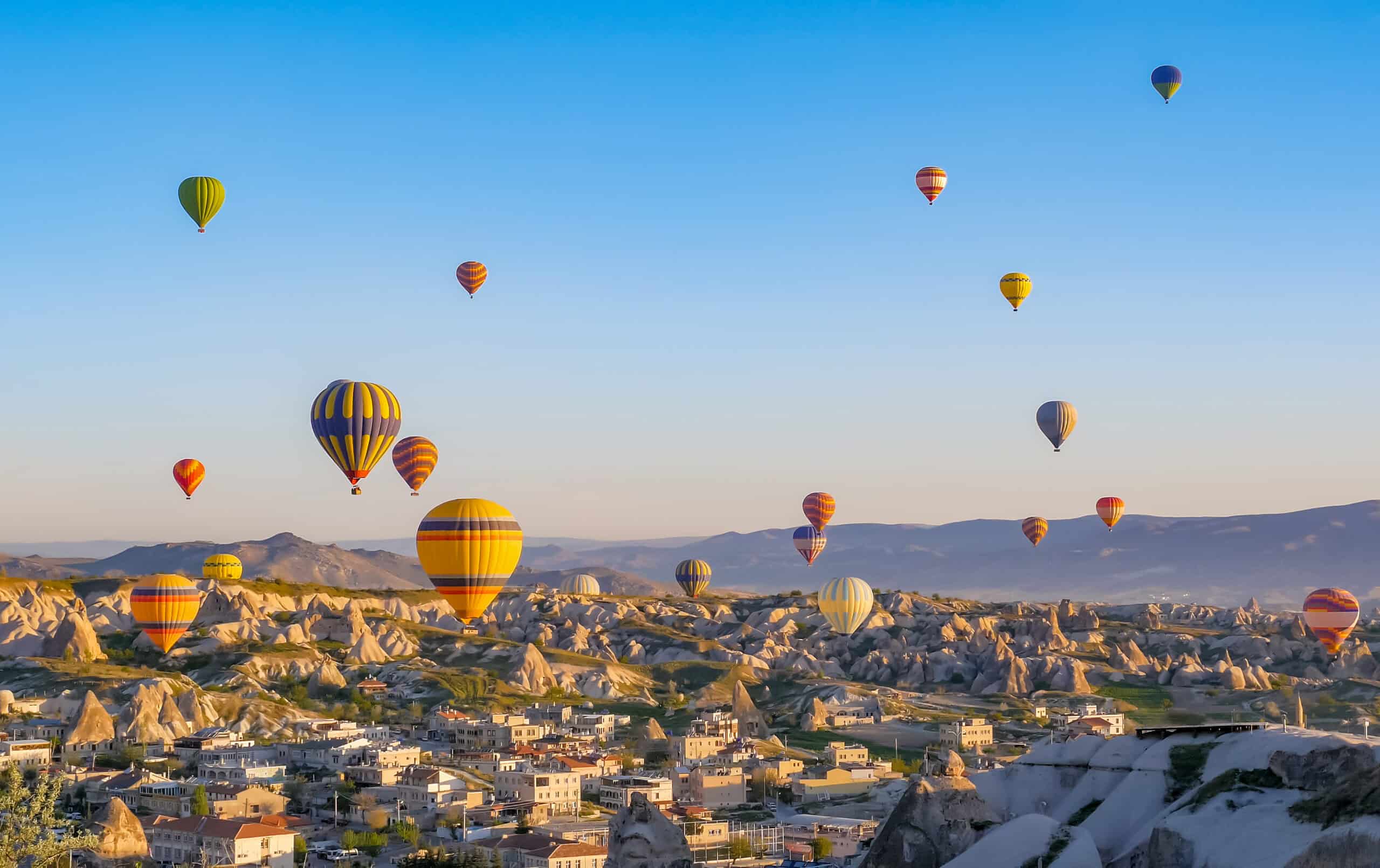 Colorful hot air balloons flying over rock landscape at Cappadocia Turkey